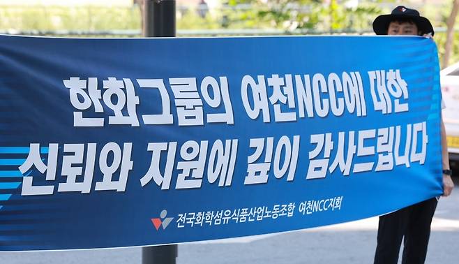 전국화학섬유식품산업노동조합 여천NCC지회 조합원이 8월 12일 서울 중구 한화빌딩 앞에서 '한화그룹의 여천NCC에 대한 신뢰와 지원에 깊이 감사드린다' 문구가 적힌 현수막을 들고 있다. 사진=연합뉴스