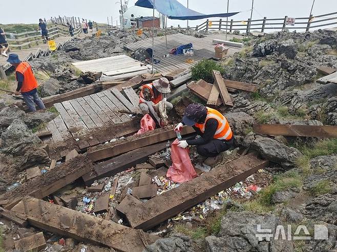 [제주=뉴시스] 제주도 세계유산본부 한라산국립공원관리소 관계자들이 21일 제주 한라산 정상 백록담 동능 데크 철거 과정에서 나온 쓰레기를 수거하고 있다. (사진=제주도 세계유산본부 한라산국립공원관리소 제공) 2025.08.22. photo@newsis.com  *재판매 및 DB 금지