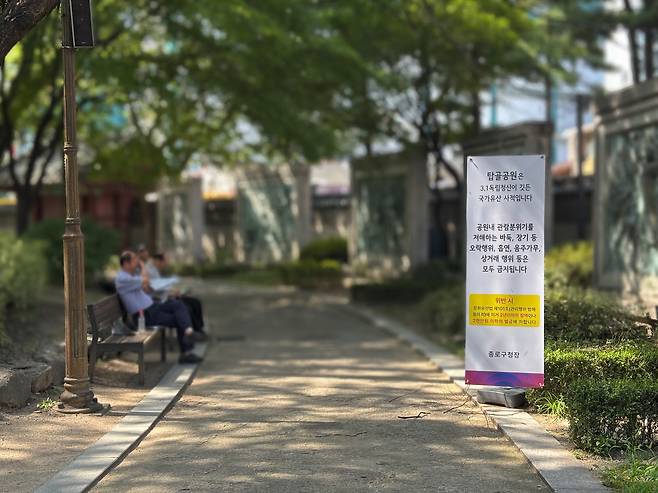 탑골공원 안내문 앞 벤치에서 쉬는 노인들 [촬영 = 김민서 인턴]