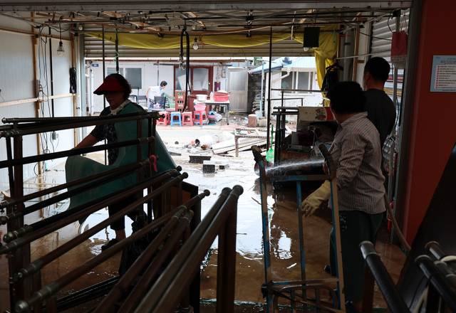 최근 집중호우로 침수 피해를 본 전남 함평천지전통시장에서 상인들이 복구작업하고 있다. 연합뉴스