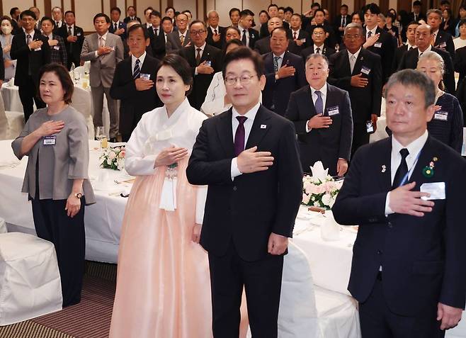 한일 정상회담을 위해 일본을 방문중인 이재명 대통령과 김혜경 여사가 23일(현지 시간) 일본 도쿄의 한 호텔에서 열린 재일동포 오찬 간담회에서 국민의례를 하고 있다. 사진=뉴시스
