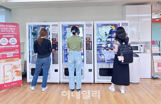 교원그룹 사내 휴게공간에 마련된 ‘1000원의 행복’ 자판기를 이용하는 직원들. (사진=교원그룹)