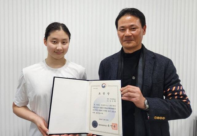 김범준 경기도수영연맹 회장(오른쪽)이 15세 배영 에이스 김승원에게 문화체육관광부장관 표창장을 전달하고 있다. . 출처=경기도수영연맹