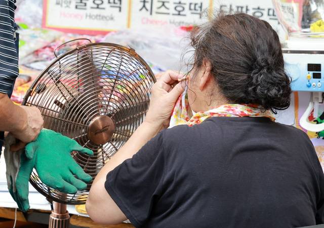 지난달 23일 오후 서울 종로구 광장시장에서 한 상인이 땀을 닦고 있다. / 뉴시스