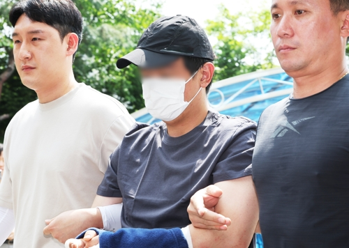 경기 용인시에서 30대 여성을 살해한 뒤 달아났다 강원 홍천군 야산에서 긴급 체포된 살인 용의자 A씨가 지난 22일 경기도 용인서부경찰서로 압송되고 있다.   [연합뉴스]
