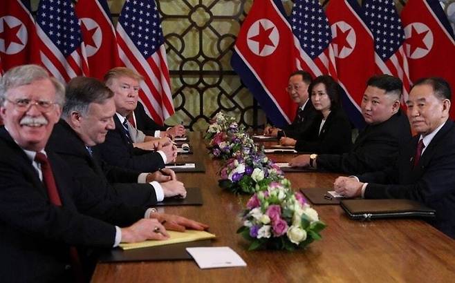 2019년 2월28일 하노이 북-미 정상회담 당시 배석한 존 볼턴 백악관 국가안보보좌관(맨 왼쪽)이 웃고있다. 그의 옆에 굳은 얼굴을 한 트럼프 대통령이 보인다. 탁자 건너편에는 김정은 국무위원장을 비롯한 북한 대표단이 앉아있다. 하노이/로이터 연합뉴스