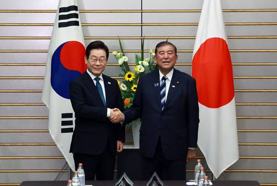 이재명(왼쪽) 대통령과 이시바 시게루 일본 총리가 23일 일본 도쿄 총리 관저에서 열린 한일 확대정상회담에 앞서 기념촬영을 하며 악수하고 있다. 연합뉴스