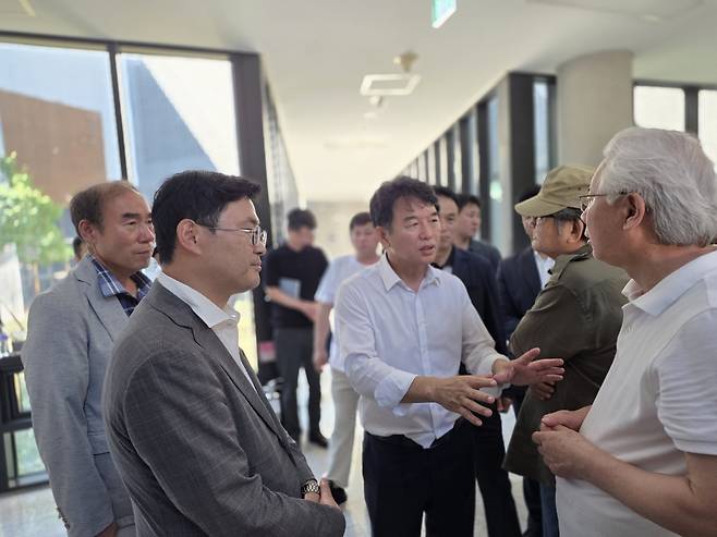 관장실 앞 시위를 저지당했던&nbsp;독립운동가 후손·광복회 유족 등을 겨레집으로 진입시킨 후 질서 있는 시위를 중재하는 문진석(중앙)·이정문(왼쪽 두번째) 의원.
