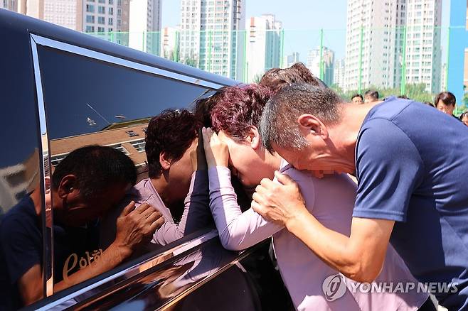 "내 딸아, 이렇게 보낼 수는 없다"  2023년 9월 9일, 학부모의 악성 민원으로 하늘나라로 떠난 대전 용산초 심미영(가명) 선생님 발인식이 열렸다. 운구 차량이 심 선생님이 재직하던 초등학교에 들러 마지막 인사를 하자, 고인의 어머니와 아버지가 차량에 기대어 오열하고 있다.
[연합뉴스 사진]