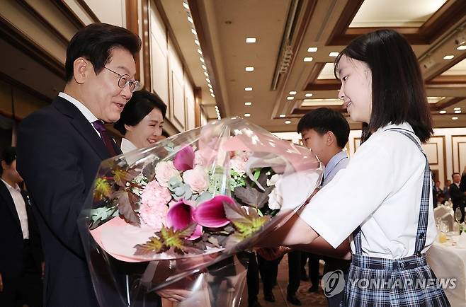 재일동포 간담회, 화동으로부터 꽃다발 받는 이재명 대통령 부부 (도쿄=연합뉴스) 한상균 기자 = 이재명 대통령과 김혜경 여사가 23일 일본 도쿄의 한 호텔에서 열린 재일동포 오찬 간담회에 참석해 화동으로부터 꽃다발을 받고 있다. 2025.8.23 xyz@yna.co.kr