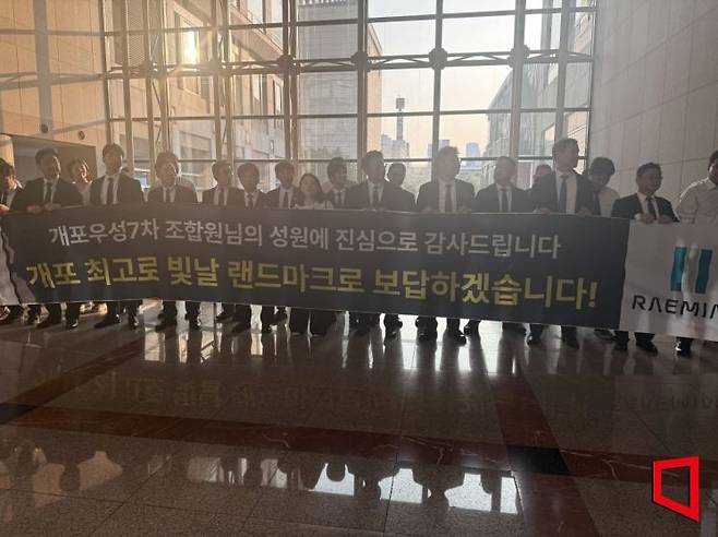 지난 23일 개포우성7차 재건축 조합이 개최한 시공사 선정 총회에서 68표 차로 삼성물산이 대우건설을 누르고 시공사로 선정됐다. 선정 직후 임직원들이 현수막을 들고 조합원들에게 인사하고 있다. 한진주 기자