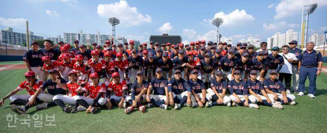 성남고 야구부원들이 24일 서울 목동구장에서 열린 제53회 봉황대기 전국고교야구대회에서 8강 진출을 확정한 후 자매결연을 맺은 대만 보문고 학생들과 기념 촬영을 하고 있다. 박시몬 기자