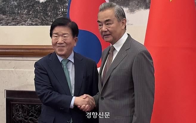 이재명 대통령의 중국 특사단을 이끄는 박병석 전 국회의장(왼쪽)이 24일 베이징 댜오위타이 국빈관에서 왕이 중국 공산당 외사판공실 주임 겸 외교부장을 만나 악수하고 있다. 베이징특파원 공동취재단