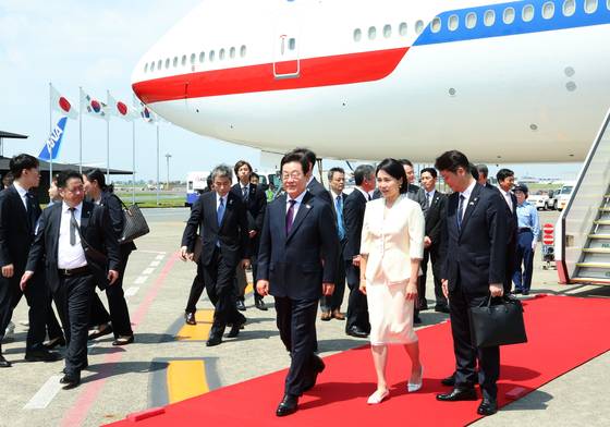 President Lee Jae Myung, left, and first lady Kim Hea Kyung arrive at Haneda Airport on Aug. 23 for a two-day visit to Japan before heading to the United States. [JOINT PRESS CORPS]