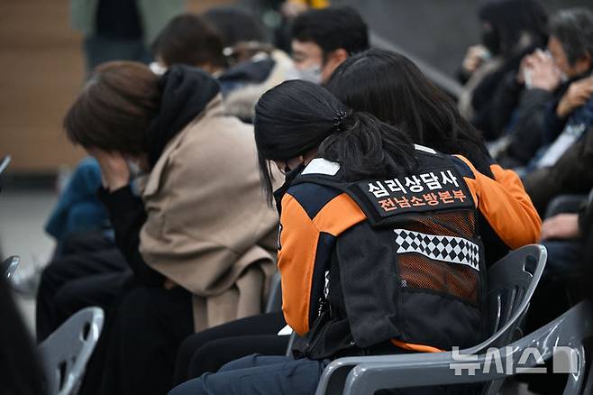 [무안=뉴시스] 이영주 기자 = 12·29 제주항공 여객기 참사 49일째를 맞는 15일 전남 무안군 무안국제공항에서 참사 49재 봉행에 참석하고 있는 한 유족이 전남소방본부 심리상담사로부터 위로받고 있다. 2025.02.15. leeyj2578@newsis.com
