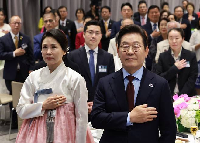 이재명 대통령과 김혜경 여사가 24일(현지시간) 미국 워싱턴DC의 한 호텔에서 열린 동포 만찬 간담회에서 국기에 경례하고 있다.(사진=연합뉴스)