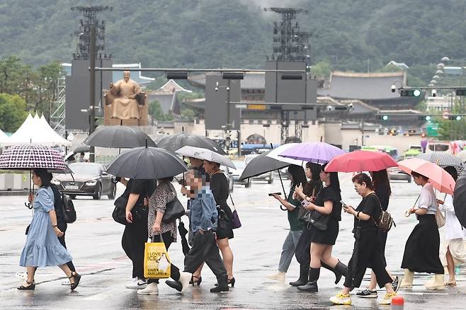서울 종로구 광화문네거리에서 우산을 쓴 시민들이 출근길 발걸음을 옮기고 있다. 사진=뉴스1