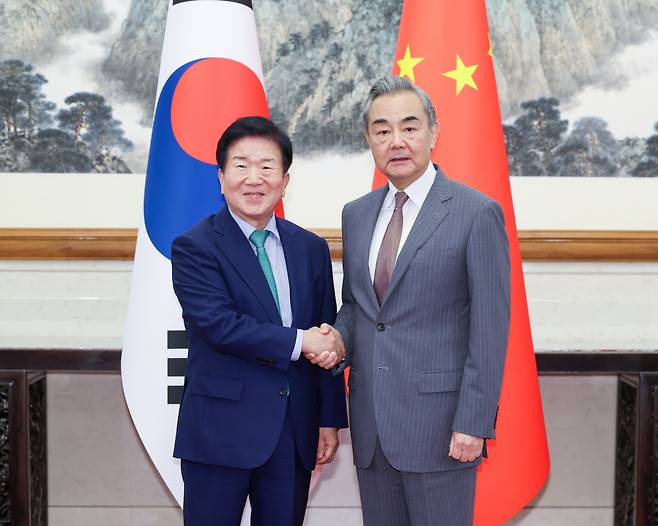 왕이 외교부장에 ‘이 대통령 친서’ 전달…경주APEC 시 주석 초청도 이재명 대통령의 중국 특사단 단장인 박병석 전 국회의장(왼쪽)이 왕이 중국 외교부장을 24일 베이징 댜오위타이 국빈관에서 만나 악수하고 있다. 신화연합뉴스