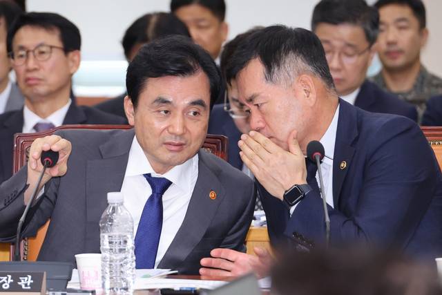 안규백(왼쪽) 국방부 장관과 석종건 방위사업청장이 25일 국회 국방위원회 전체회의에서 대화하고 있다. 연합뉴스