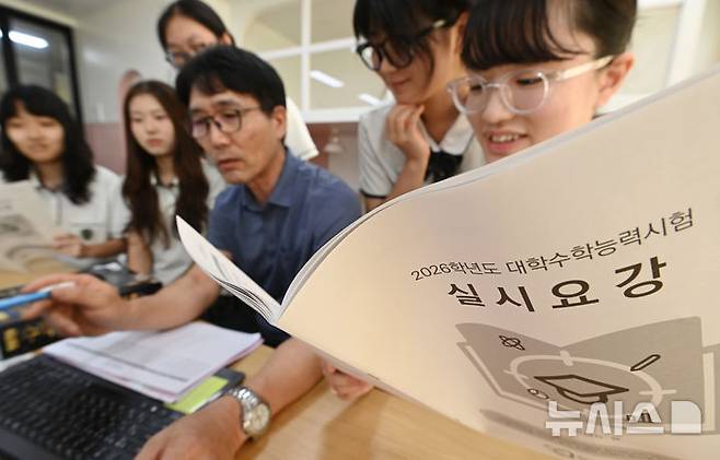 [수원=뉴시스] 김종택 기자 = 2026학년도 대학수학능력시험 응시원서 접수가 시작된 21일 경기 수원시 영복여자고등학교에서 고3 수험생들이 선생님과 함께 수능 실시요강 등을 살펴보고 있다. 2025.08.21. jtk@newsis.com **기사 내용과 직접 관련 없습니다**