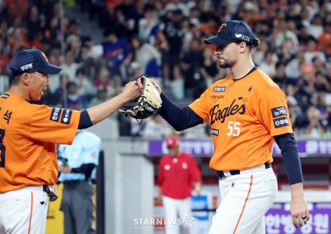 이닝을 마친 와이스(오른쪽)가 김우석 코치의 환영을 받으며 더그아웃으로 들어오고 있다. /사진=강영조 선임기자