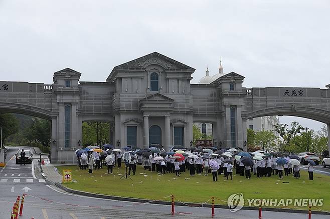김건희 특검, 통일교 압수수색 (가평=연합뉴스) 임병식 기자 = 김건희 여사의 각종 의혹들을 수사하는 민중기 특별검사팀이 통일교 시설과 관계자를 대상으로 압수수색에 나선 18일 오전 경기도 가평군 통일교 본부에서 신도들이 집회를 열고 있다. 2025.7.18 andphotodo@yna.co.kr