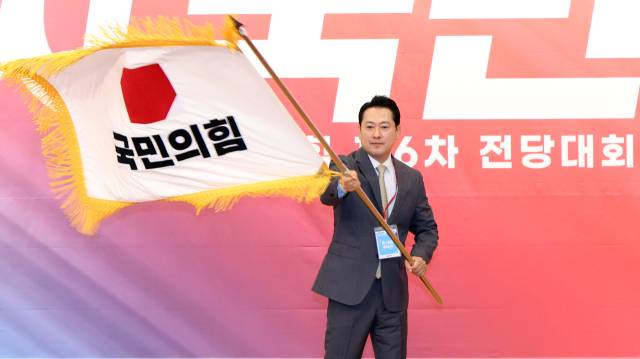 국민의힘 장동혁 신임 당 대표가 26일 서울 여의도 국회도서관에서 열린 제6차 전당대회 결선에서 당 대표로 선출된 뒤 당기를 흔들고 있다. 연합뉴스