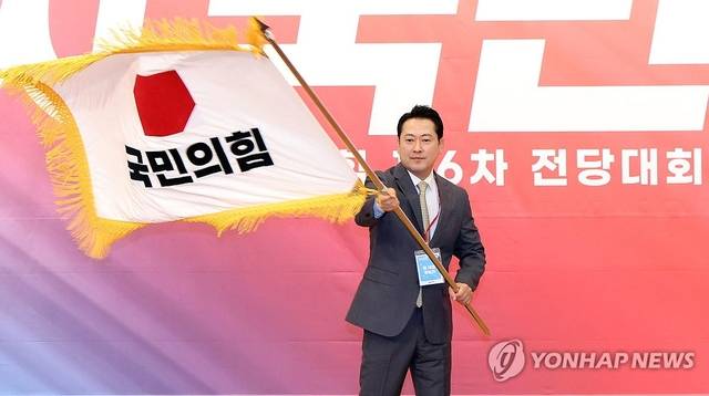 국민의힘 장동혁 신임 당 대표가 26일 서울 여의도 국회도서관에서 열린 전당대회 결선에서 당 대표로 선출된 뒤 당기를 흔들고 있다. 연합뉴스