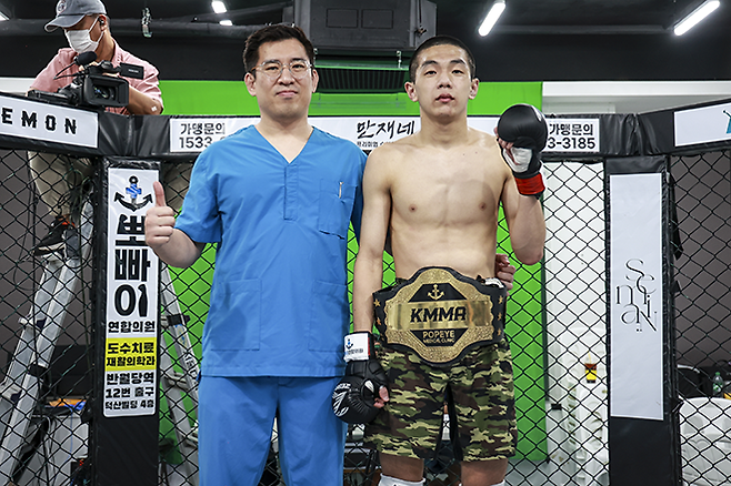 KMMA 플라이급 챔피언 문순수(오른쪽)가 KMMA 메인스폰서 뽀빠이연합의원 김성배 원장과 타이틀 1차 방어 성공 기념 촬영을 하고 있다. 사진=스탠다드앤드프로그레스 스포츠에이전시 제공