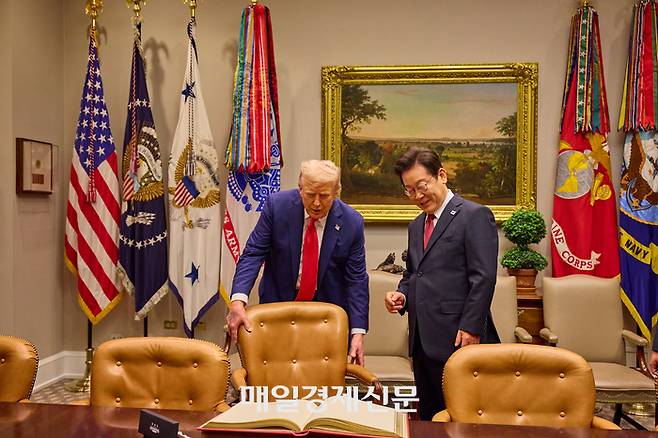 도널드 트럼프 미국 대통령이 25일(현지시간) 워싱턴DC 백악관에서 열린 한미정상회담에 앞서 이재명 대통령이 방명록을 작성할 수 있도록 의자를 빼주고 있다. ]워싱턴DC/김호영기자]