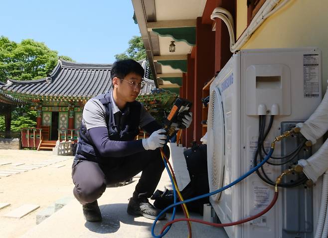 삼성전자서비스 엔지니어가 산사를 직접 방문해 에어컨 실외기를 점검하는 모습. / 사진=삼성전자서비스