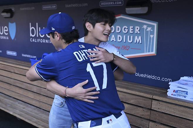 그룹 방탄소년단(BTS)의 뷔가 25일(현지시간) 미국 프로야구 메이저리그(MLB) 로스앤젤레스(LA) 다저스의 홈경기 시구에 앞서 다저스 소속 스타선수 오타니 쇼헤이와 만나 서로 끌어안고 있다. [AP=연합뉴스]