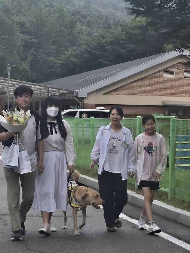 [서울=뉴시스] 삼성화재 안내견 태극이와 태극이의 파트너(왼쪽), 태극이를 1년동안 돌봐준 자원봉사자 퍼피워커 가족(오른쪽)이 함께 걷고 있다. (사진=권안나 기자) 2025.08.26. mymmnr@newsis.com *재판매 및 DB 금지