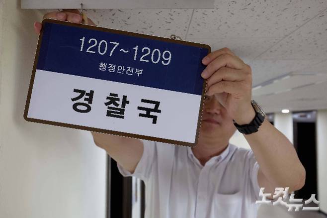 행정안전부 산하 경찰국이 폐지된 26일 서울 종로구 정부서울청사 내 경찰국 사무실 앞에서 관계자가 현판을 제거하고 있다. 박종민 기자