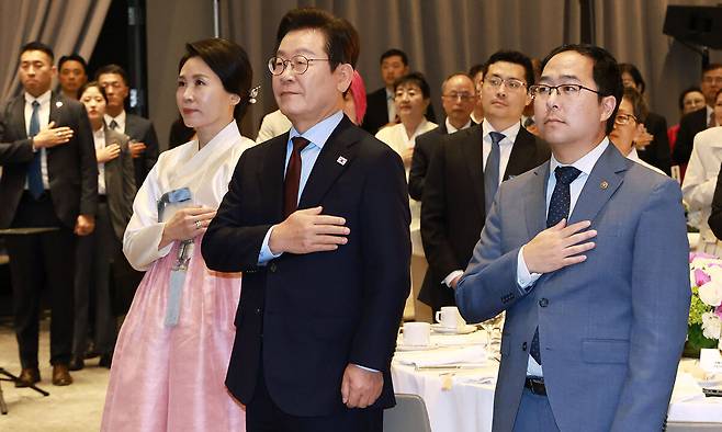 이재명 대통령과 김혜경 여사가 24일(현지시간) 미국 워싱턴의 한 호텔에서 열린 재미동포 만찬 간담회에서 참석자들과 함께 국민의례를 하고 있다. 오른쪽은 앤디 김 미국 상원의원. 워싱턴=뉴시스