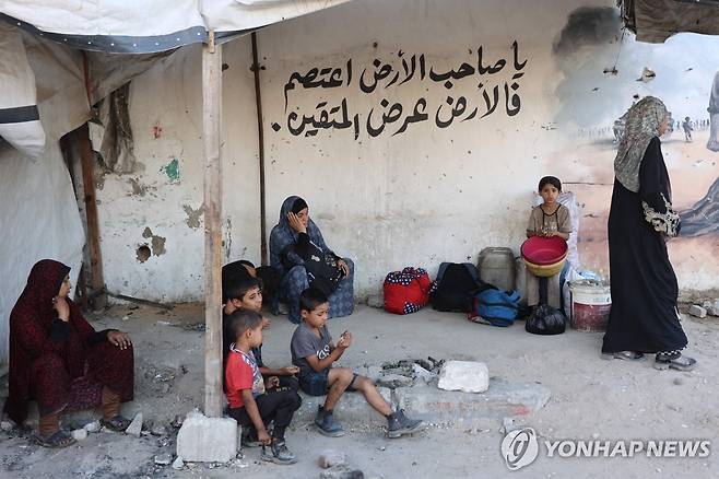 PALESTINIAN-ISRAEL-CONFLICT 26일(현지시간) 가자시티의 자이툰 인근에서 팔레스타인 주민들이 피난 도중 길가에서 휴식을 취하고 있다. [AFP=연합뉴스]
