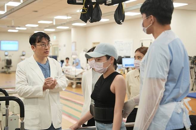 ▲ 응급외상중환자외과 신홍경(왼쪽) 교수가 엥흐진(가운데) 환자의 재활 치료에 대해 상의하는 모습. /사진제공=분당서울대병원 /성남=김규식 기자 kgs@incheonilbo.com