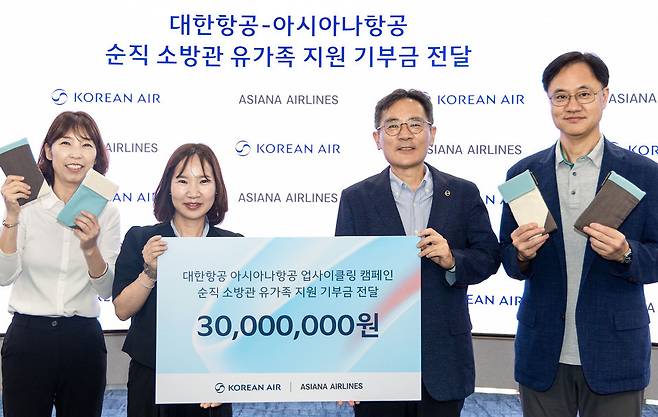 ▲ 대한항공과 아시아나항공이 객실승무원 폐유니폼을 활용해 먄든 보조배터리 파우치를 판매 수익금과 기부금 등 3000만원을 소방가족희망나눔에 전달했다. /사진제공=대한항공