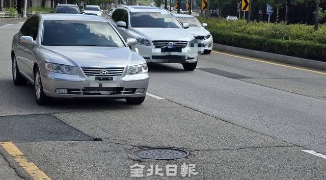 맨홀로 인해 단차가 발생한 전주시 완산구의 도로를 지나는 차량들. 김문경 기자