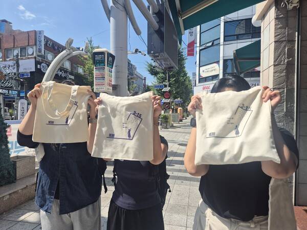 지난달 11일, 마산 3·15의거 발원지 기념관 앞에서 열린 시민 캠페인에서 학생들이 직접 &nbsp;제작한 3·15 기념 에코백을 시민들에게 나눠주고 있다. /마산여고