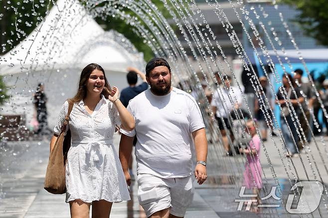 서울 광화문광장 분수터널에서 외국인 관광객들이 더위를 식히고 있다. 2025.6.8/뉴스1 ⓒ News1 이동해 기자