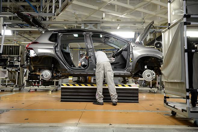 프랑스 자동차 제조업체 PSA 푸조 시트로엥 공장 조립 라인에서 PSA 직원이 차량을 손보고 있다. /연합뉴스