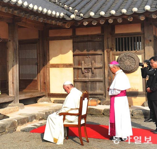 2014년 8월 15일 방한한 고 프란치스코 교황이 솔뫼성지 내 성 김대건 신부 생가 앞에서 기도를 드리고 있다. 뒤에 서 있는 사람은 당시 대전교구 장인 유흥식 추기경. 동아일보 DB