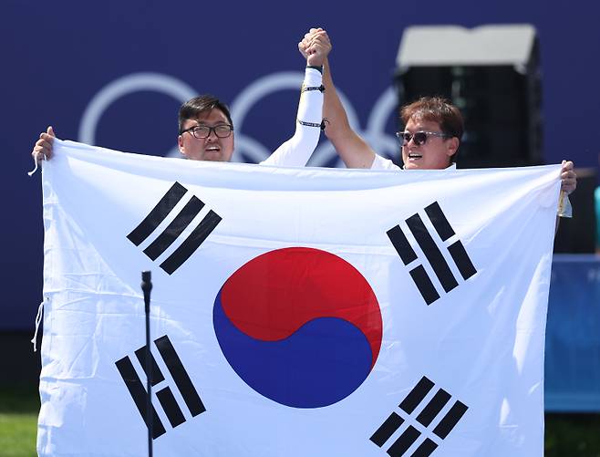 <yonhap photo-6803=""> 파리 올림픽 남자 양궁 개인전에서 우승한 김우진과 그를 지도한 대표팀의 박성수 감독.&nbsp; &nbsp;<저작권자 ⓒ 1980-2024 ㈜연합뉴스. 무단 전재 재배포 금지, AI 학습 및 활용 금지></yonhap>