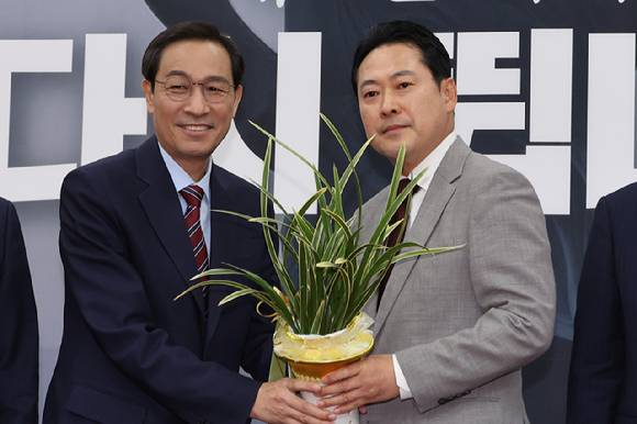 우상호 대통령실 정무수석이 27일 서울 여의도 국회에서 국민의힘 장동혁 신임 대표를 예방해 이재명 대통령이 보낸 축하난을 전달하고 있다. 2025.8.27 [사진=연합뉴스]