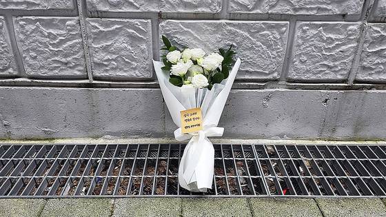 '강서 세 모녀'가 옥상에서 추락해 사망한 현장 곁에 주민자치회가 두고 간 꽃다발이 놓여 있다. 김창용 기자