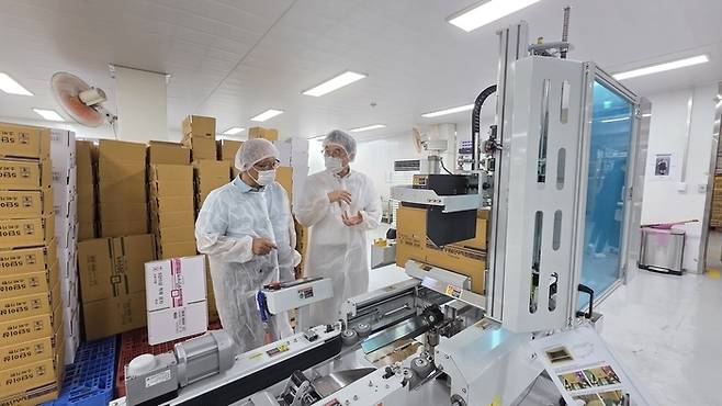 김경범 자연그린 대표이사(왼쪽)와 박노정 삼성전자 ESG&스마트공장지원센터 위원이 제품 박스 자동화 공정에 대해 상의하고 있다. [삼성전자]