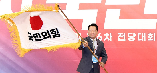 장동혁 국민의힘 신임 당 대표가 26일 서울 여의도 국회도서관에서 열린 제6차 전당대회 결선에서 당 대표로 선출된 뒤 당기를 흔들고 있다.