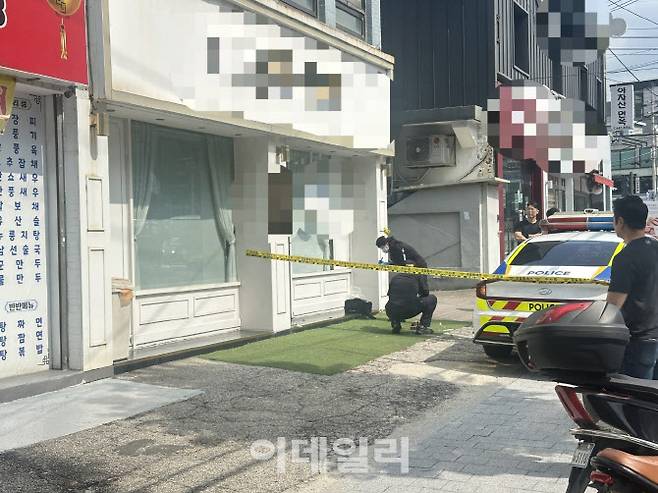 28일 오전 서울 광진구 구의동의 한 펫샵에서 경찰이 깨진 유리문을 살피고 있다. (사진=박원주 수습기자)