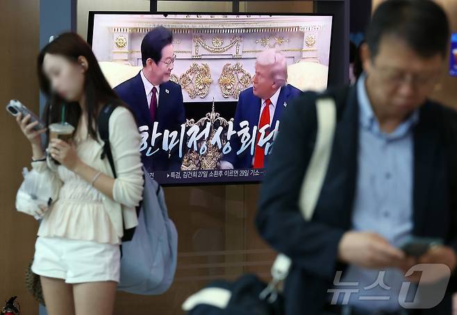 26일 오전 서울 용산구 한강대로 서울역 대합실에서 시민들이 이재명 대통령과 도널드 트럼프 미국 대통령 간 한미 정상회담 관련 뉴스를 지켜보고 있다. 2025.8.26/뉴스1 ⓒ News1 박정호 기자